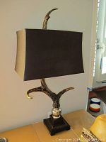 Full front view of the faux antler table lamp showing overall shape, shade, and base