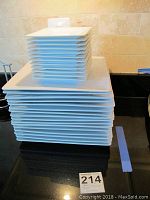 Stack of 16 large and 12 small white square plates, showing clean condition and modern design.