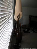 Side view of the floor lamp and wood vase showing the height and slender shapes