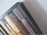 Close-up of the top corner of the wooden frame showing texture and natural wood pieces in varied tones.
