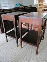 Photo showing two rectangular wooden night stands side by side with dark finish, one in front and one behind, showing top and side views, legs, shelf and drawer box.