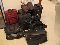 Overview shot of entire luggage set showing carry-ons, garment bags, briefcases, duffels, and backpacks together.