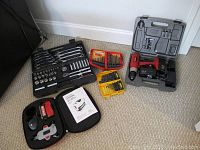 Full lot overview showing socket wrench set, level, various drill bit sets, and cordless drill.