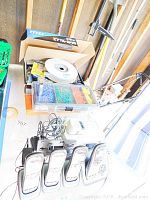 Four Uniden cordless phone handsets with LCD screens on base unit and a socket ratchet set with assorted sockets and a small organizer box with nails or screws.