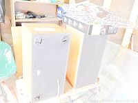 Bottom of one large wooden speaker showing four small feet and part of a power cord or cable.