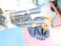 Electric leaf blower with blower tube and black vacuum bag attachment.