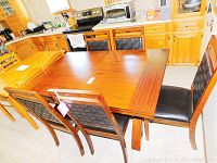 Set of six wood and vinyl dining chairs around a wood table in kitchen.