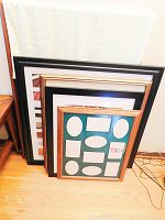 Set of 6 picture frames leaning against a wall, showing variety in sizes and finishes, one frame missing glass