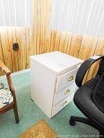 White faux wood night stand with three drawers shown from front and side angles, some wear visible on top and drawers.