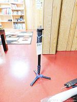 Full view of Koolehaoda K288 monopod standing on the floor, showing the tripod-style foldable legs, black body, and height approximately 20 inches.