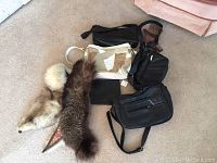 Overall view of lot showing all purses, fur collars, gloves, and makeup bag on carpeted floor