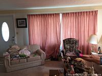 Wide shot of a living room with dusty rose drapes fully covering windows, includes furniture and room context.