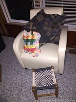 Vinyl club chair off-white color with three cushions and small stool in the foreground