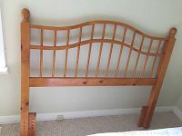 Full view of the solid wood headboard showing the curved top and vertical slats