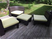Full patio furniture set arranged on deck, showing two chairs, loveseat, ottoman with yellow cushions