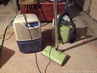 View of Simplicity dehumidifier and Kenmore vacuum on concrete floor with visible cords and hoses