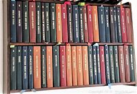 Two-tier wood wall shelving with 46 leather-bound books