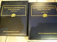 Two closed hardcover binders labeled The United States Presidents Coin Collection Volume I and Volume II by Postal Commemorative Society shown from the front.