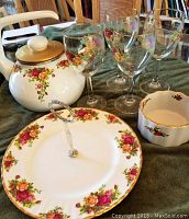 Full view of seven-piece set displaying teapot, serving tray, small bowl, and four matching wine glasses featuring Old Country Roses floral pattern with gold trim.