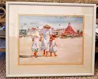 Front view of framed print showing three girls walking on beach toward Hotel Del Coronado with white frame and matting.