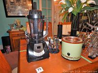 Photo of Health Master blender, Rival crock pot, and rotating utensil set on kitchen counter with plants in background