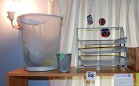 Photo showing the wire mesh trash bin, pencil cup, and 3-tier tray organizer on a wooden shelf.