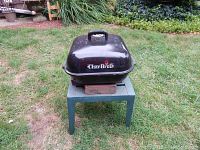 Front view of black Charbroil portable BBQ grill with lid closed, showing the logo, handle, and ventilation on top.