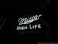 Front view of the Miller High Life neon sign illuminated in white, main text glowing.