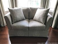 Front view of silver grey custom made loveseat showing two seat cushions, two back pillows, flared arms, patterned upholstery