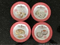 Four porcelain cheese plates arranged together showing detailed cheese illustrations and red gingham border.