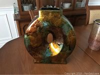 Front view of the modern green and gold glaze flower vase with circular form and hollow center