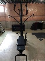 Front view of Bowflex gym and bench showing power rod tower, pulley arms, and bench