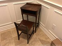 Wooden antique telephone table and matching chair positioned near wall corner on tile floor