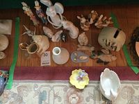 Top view of the collection showing all ceramic figurines and pottery including piggy bank, rabbits, angel, birds, and swan dish.