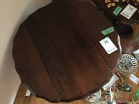 Top view of one table showing dark wood scalloped edge and drop leaves extended