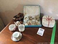 Full view of the collection on a wooden surface showing the porcelain miniature tea set, boxes, and various small porcelain items.