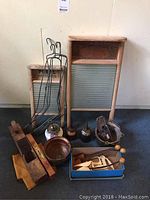 View of multiple items including wooden wash boards, metal sock dryers, wooden shoe trees, old oil cans, spirit level, copper bowl, and box of smaller tools.