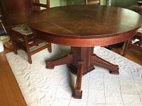 Round quarter-cut oak dining table with pedestal base