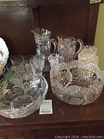 Thistle etched serving bowl at left, lattice rim fruit bowl at right, two pitchers behind