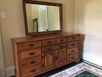 View of the full Roxton maple triple dresser showing 10 drawers and two central cabinet doors with ornate metal handles.