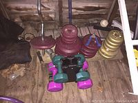 Weight bench with dumbbells, weights, ab roller, curl bar, and grip exerciser in a wooden room