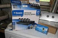 Swann Advanced-Series D1 security system box showing 4 channel digital video recorder and 4 cameras packed inside.