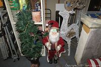 The entire lot including Santa figure, Christmas tree, and white reindeer displayed together in a storage area.