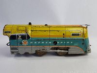 Side view of an early Hafner steel wind-up train with yellow, turquoise, and silver paint, showing wear and paint chipping.