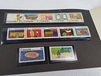 Photo of the 1970 Canada Christmas mint stamp set displayed in black folder, showing rows of colorful stamps with 5, 6, 10, and 15 cent denominations featuring Christmas-themed illustrations.