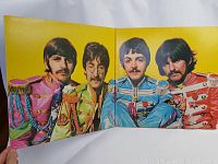 Inner gatefold photo of the Beatles in colorful military-style jackets.
