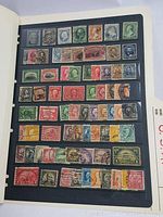 Photo of a black album page with multiple vintage used American stamps in horizontal rows