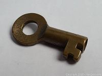 Brass railway key front view showing circular bow and notched bit