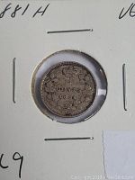 Front view of 1881 silver five cents coin in cardboard holder showing date, denomination, and crown with wreath.