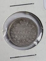 Close-up photo of the reverse side of the 1885 Canada silver five cent coin housed in a protective holder, showing the denomination and date with crown and wreath detail.